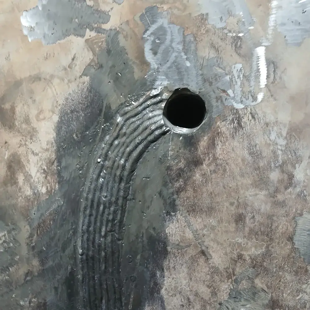 Reparo em torno de bocal, com os passes visíveis na chapa