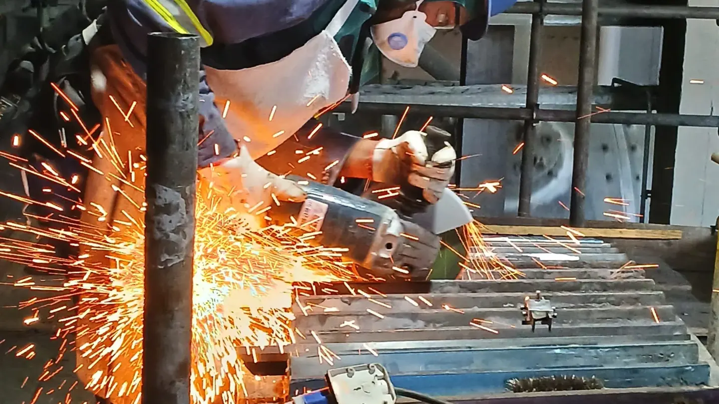 Preparação de junta com esmerilhadeira, em serviço de soldagem industrial
